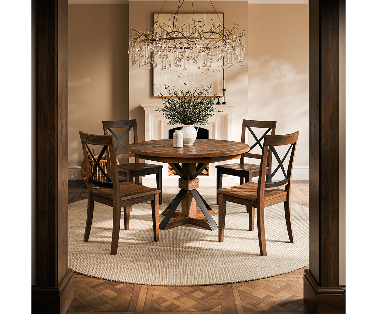 Cozy dining room vignette with round table, four chairs, chandelier, fireplace.